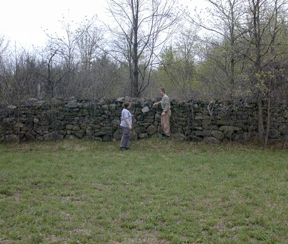 Photo of Alain Cogliastro in front of a stone wall.