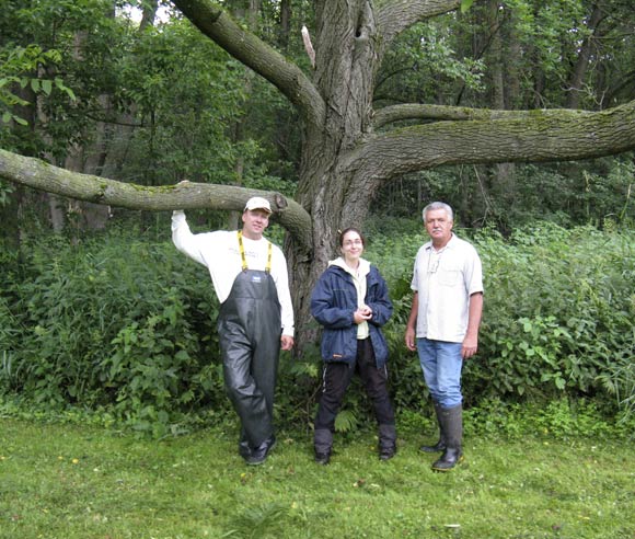 Photo of Caroline Tanguay with specialists, in front of a butternut's trunk