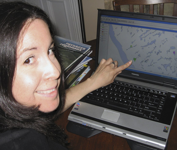 Photo d'Édith Bégin qui pointe sur un écran d'ordinateur le programme ArcGis