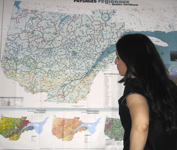 Photo d'Édith Bégin qui observe une carte géographique du Québec 