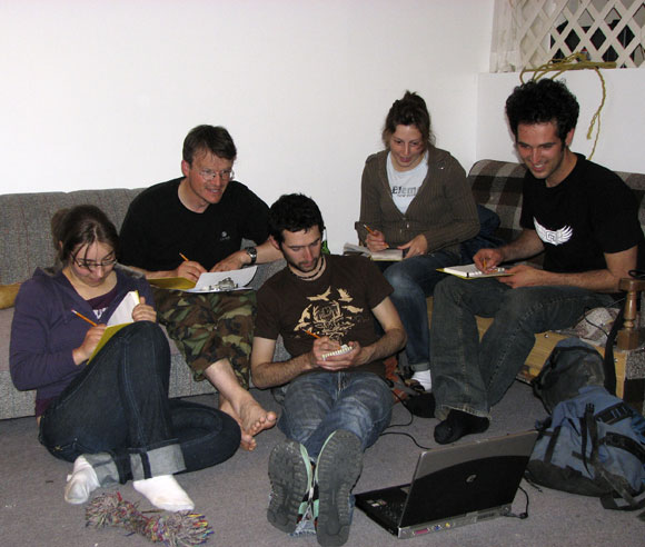 Photo of the five research members, in a cottage, taking notes
